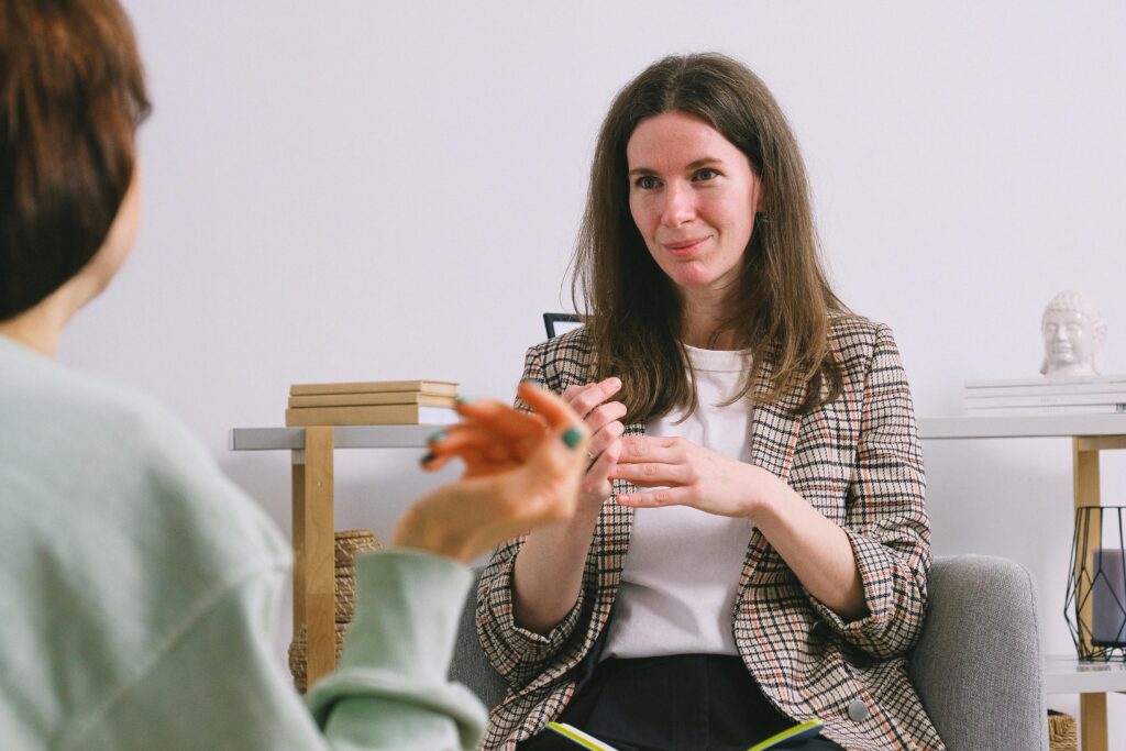 A therapist conducts a Parkinson's assessment, engaging with a patient in a calm and supportive indoor setting.