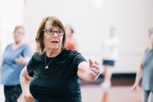 Active senior woman participating in a dance class, promoting positive aging and wellness.